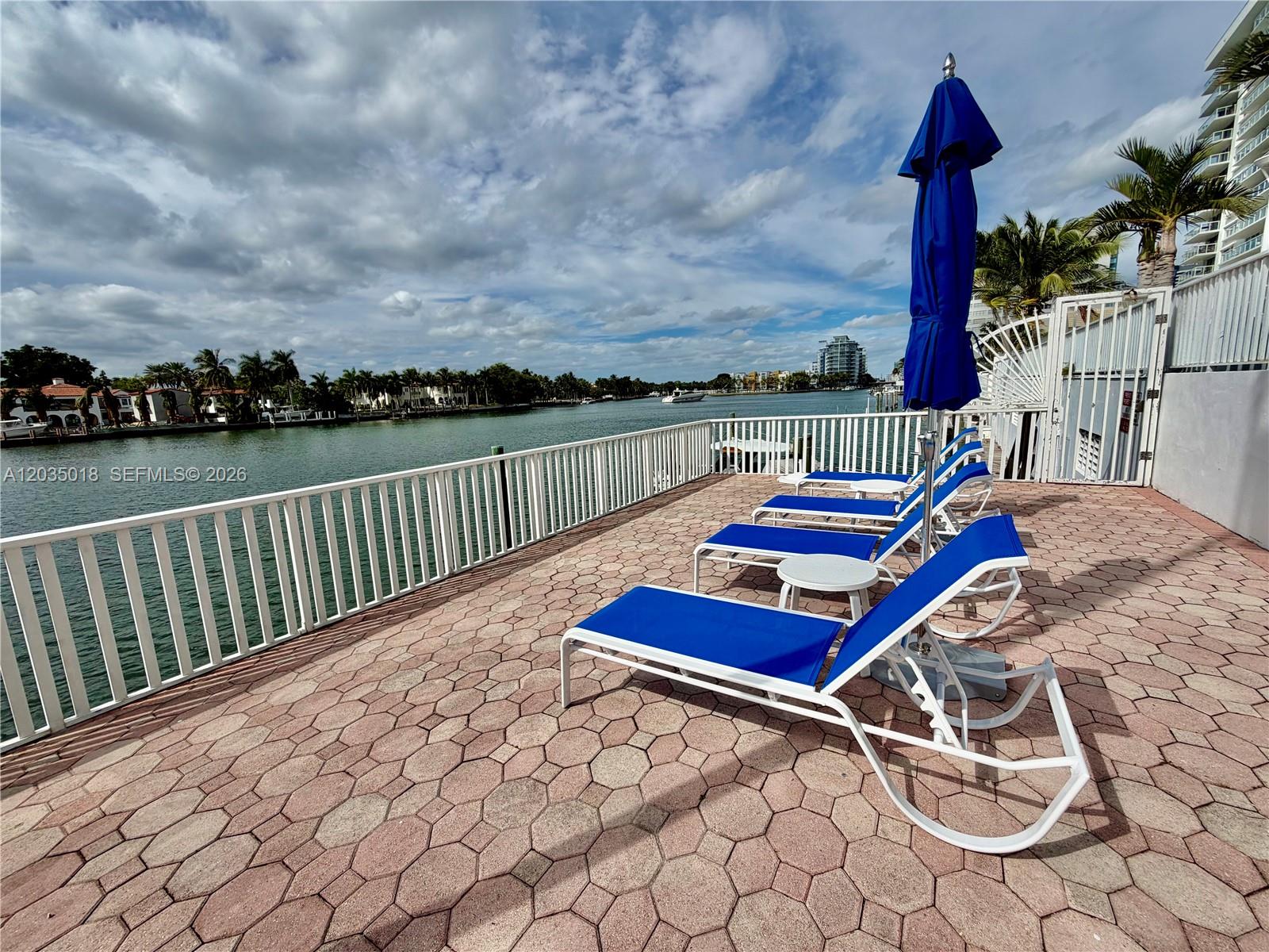 A bright lobby features two leather sofas, two armchairs, a coffee table, and large windows — 5700 Collins Ave # 14M, Miami Beach FL 33140, MIAMI BEACH, FL