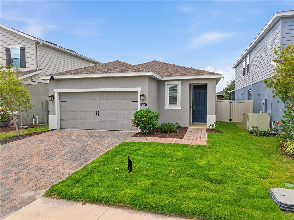 A single-story house with a gray stucco exterior, a two-car garage, and a paved driveway — 12261 BLUE PACIFIC DRIVE, RIVERVIEW, FL