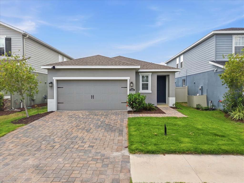 A single-story house with a gray garage, a paved driveway, and a small front lawn — 12261 BLUE PACIFIC DRIVE, RIVERVIEW, FL