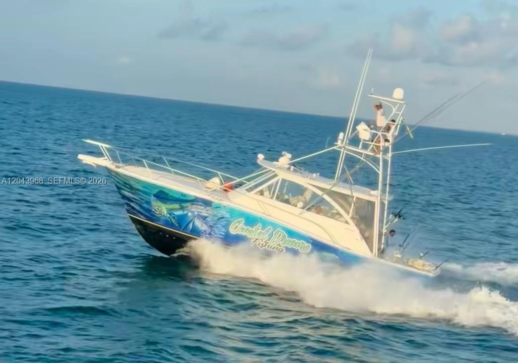 A sport fishing boat with a blue hull wrap cruises across the open ocean — 1313 Ocean Bay Dr, Key Largo FL 33037, KEY LARGO, FL