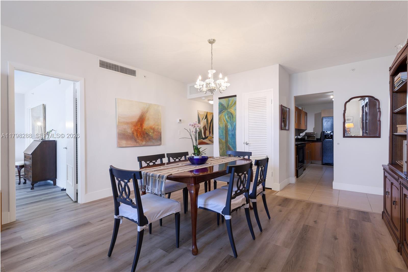 A dining room features a wooden table with six chairs, a chandelier, and wood-look flooring — 3001 S Ocean Dr # 443, Hollywood FL 33019, HOLLYWOOD, FL
