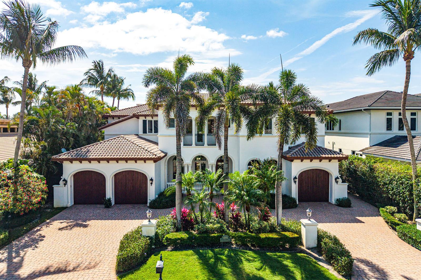 A two-story Mediterranean-style house with a brick driveway, arched garage doors, and palm trees — 1282 Sabal Palm Drive, Boca Raton FL 33432, BOCA RATON, FL
