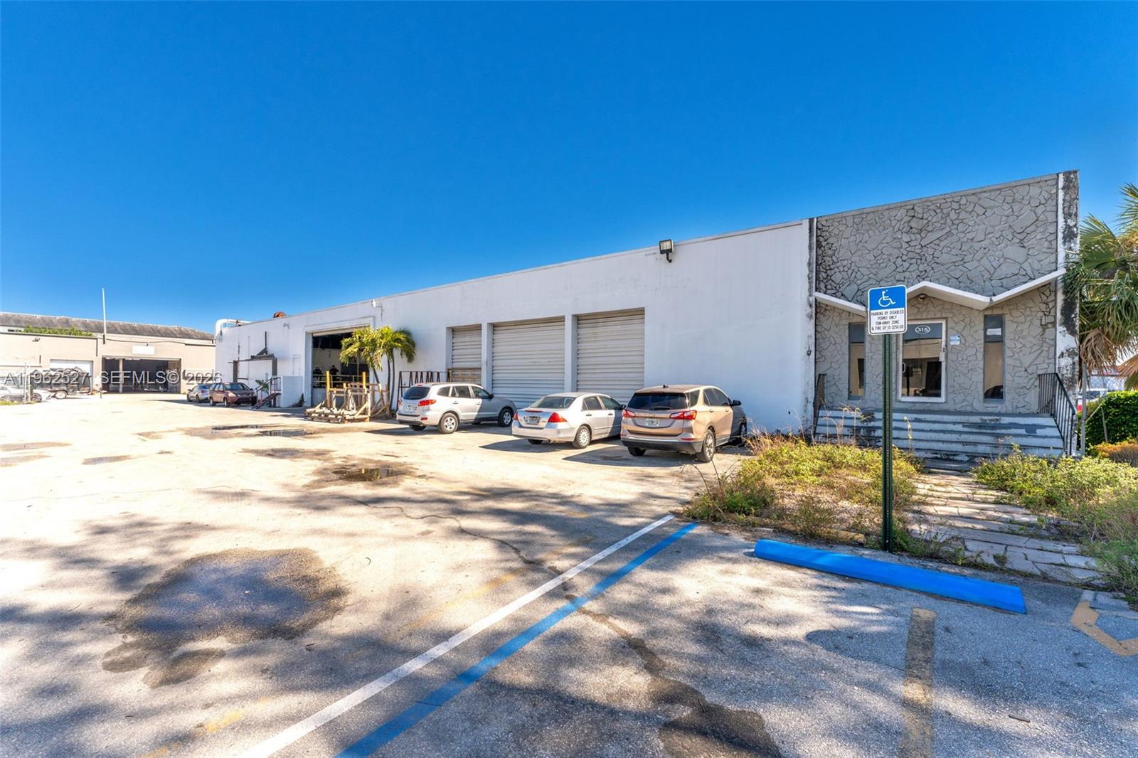 A low-rise industrial building features a paved parking lot and a stone-clad entrance — 315 W 75th Pl, Hialeah FL 33014, HIALEAH, FL