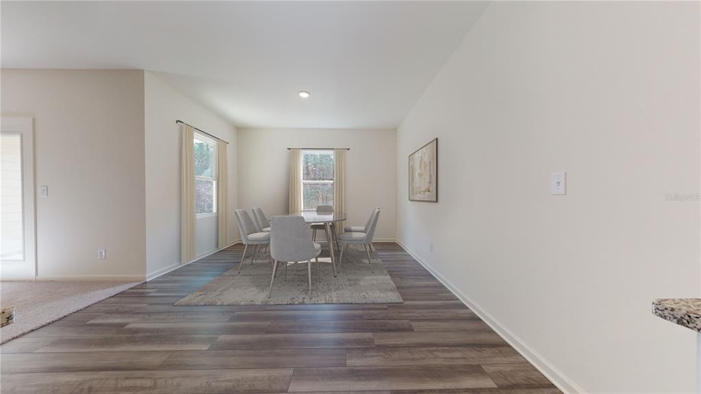 A dining area features wood-look flooring, a table with six chairs, and two windows — 13256 BENDING CREEK TRAIL, PARRISH, FL