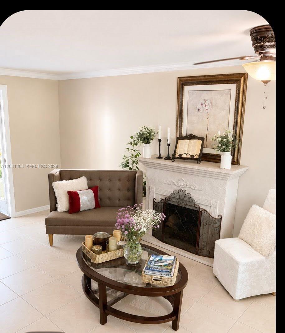 A living room features a fireplace, a small sofa, an armchair, and a glass coffee table — 13918 SW 172nd Ter, Miami FL 33177, MIAMI, FL