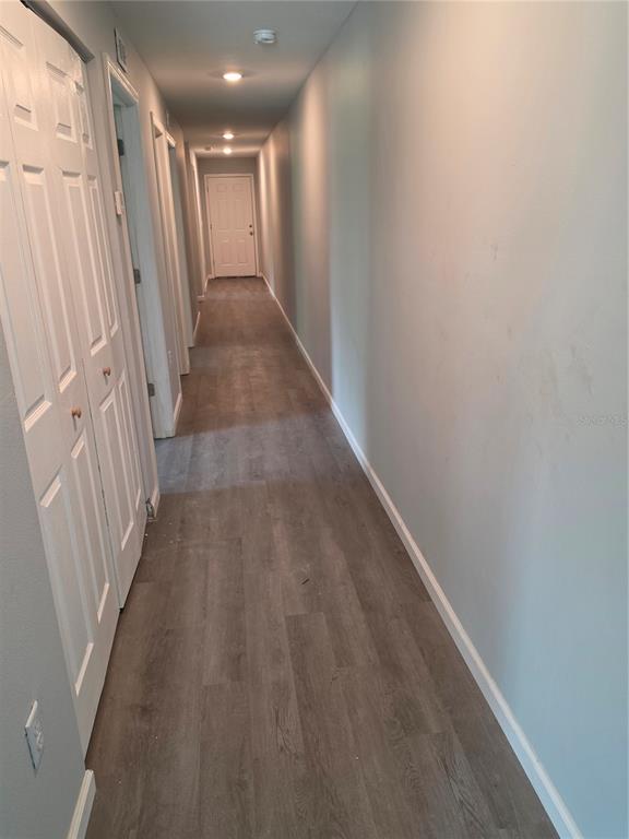 A long hallway with light gray walls, white doors, and wood-look flooring — 139 B STREET, LAKE WALES, FL