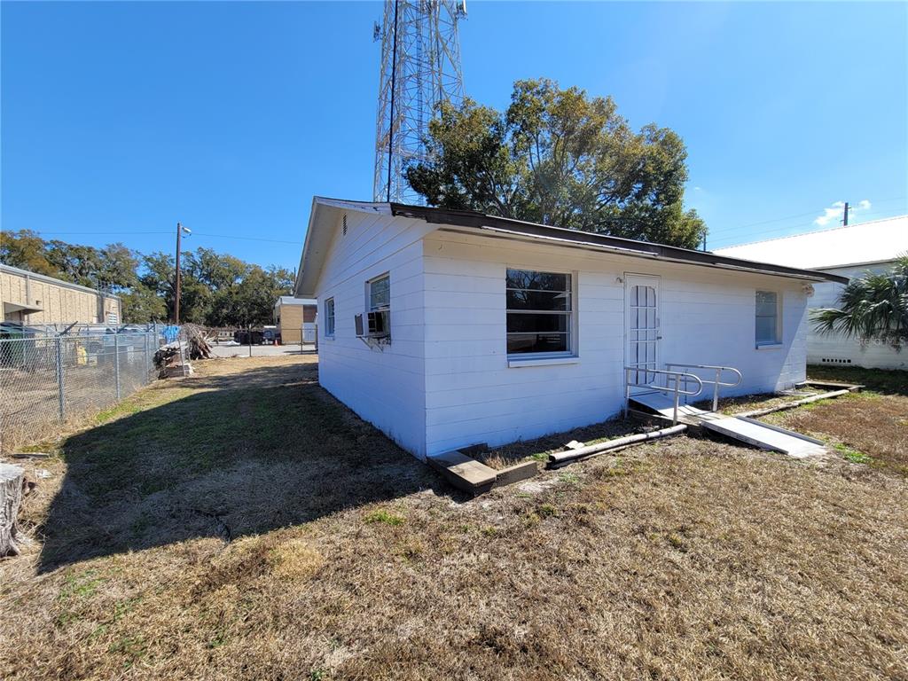 A small, white, single-story building with a metal ramp leading to the front door — 4830 GALL BOULEVARD, ZEPHYRHILLS, FL