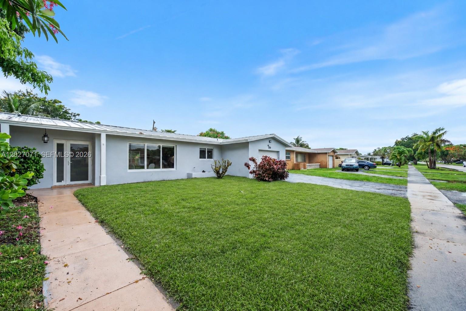 A single-story house with a white exterior, a metal roof, and a front lawn — 4024 Monroe St, Hollywood FL 33021, HOLLYWOOD, FL