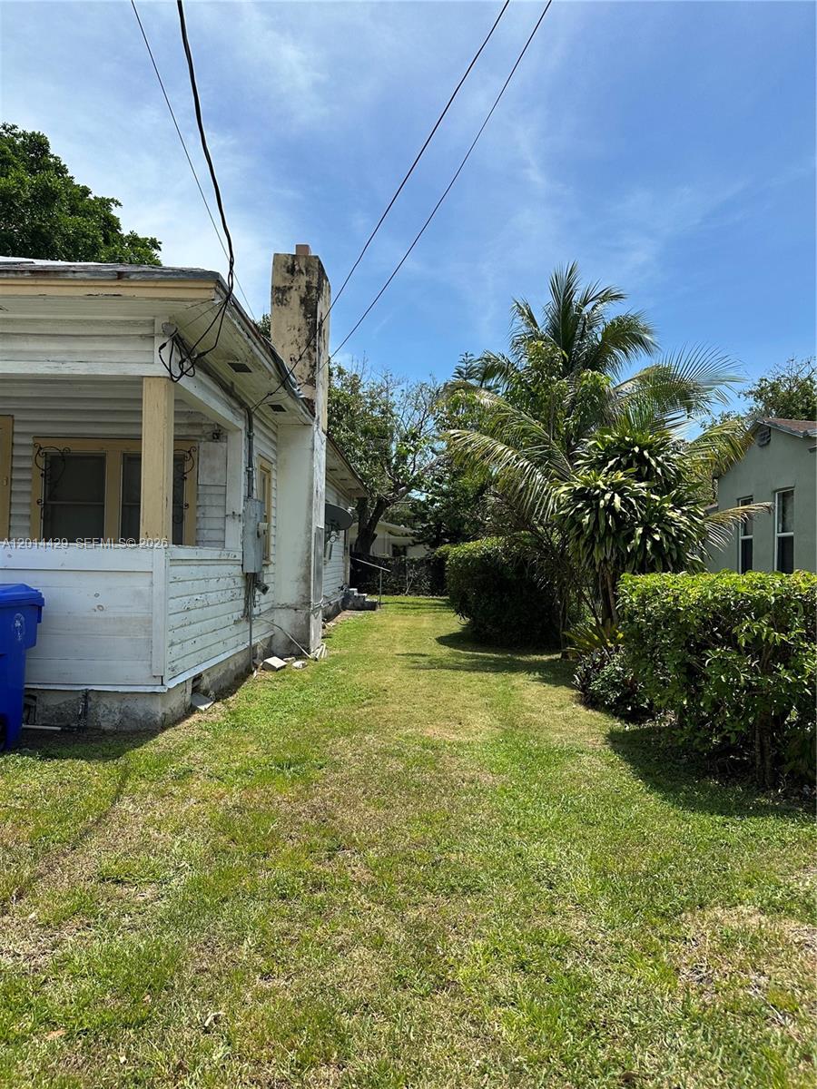 A side view of a white house with a chimney and a grassy yard — 3566 Thomas Ave, Miami FL 33133, MIAMI, FL