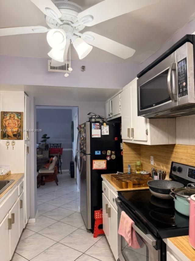 A kitchen features white cabinets, stainless steel appliances, a ceiling fan, and tiled flooring — 3850 Washington St # 409, Hollywood FL 33021, HOLLYWOOD, FL