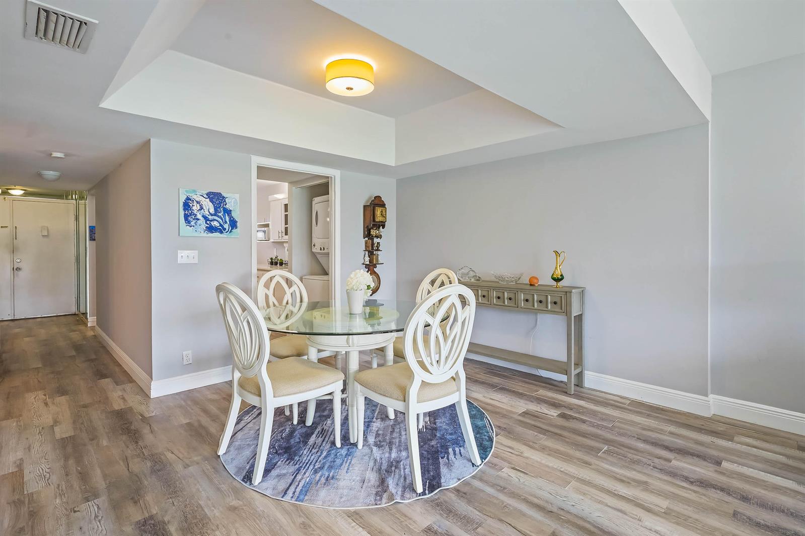 A dining area features a glass-topped table, four white chairs, and a console table — 6850 10th Avenue N # 310, FL 33467, FL