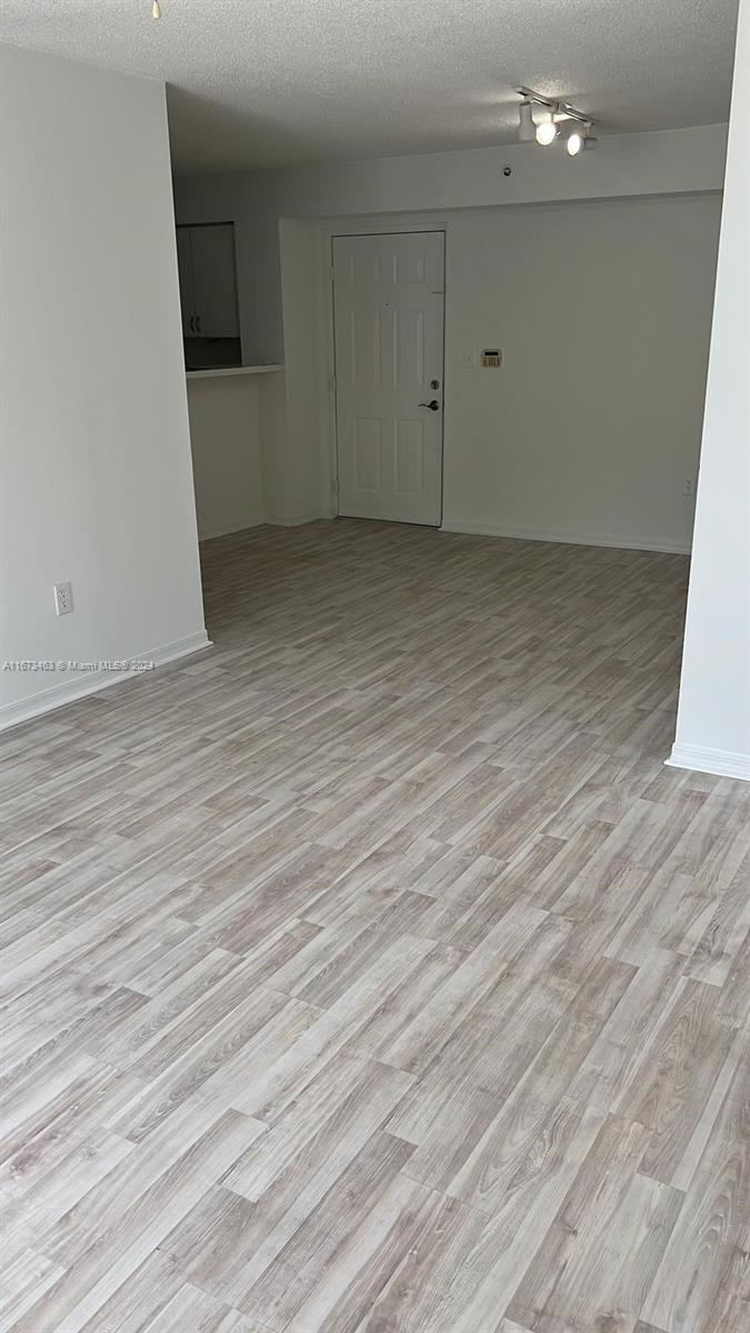 This interior view shows an open living area with light wood-look flooring and a white door — 4350 NW 107th Ave # 2, Doral FL 33178, DORAL, FL