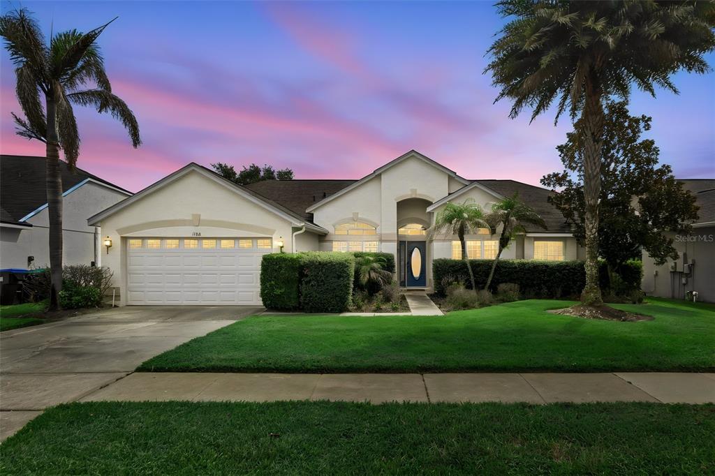 A single-story house with a two-car garage, a manicured lawn, and two tall palm trees — 14313 ROXSHIRE DRIVE, ORLANDO, FL