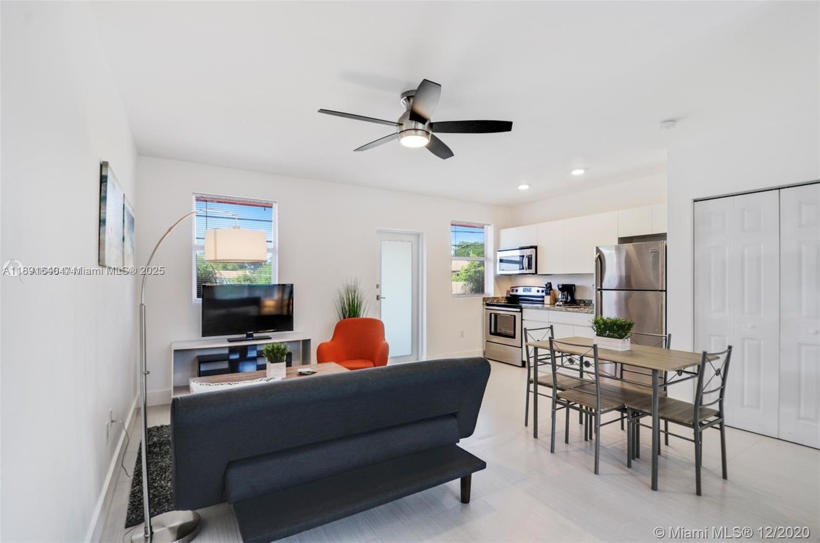 A living room and kitchen area with white walls, tile floors, and stainless steel appliances — 2601 NW 1st Ave # 4, Miami FL 33127, MIAMI, FL