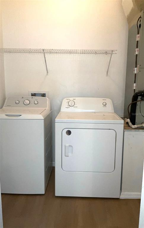 A laundry room featuring a white top-load washer and dryer beneath a wire shelf — 1318 LAKE BISCAYNE WAY, ORLANDO, FL