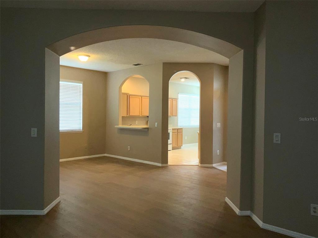 An interior view shows a living area with arched doorways leading to a kitchen — 1318 LAKE BISCAYNE WAY, ORLANDO, FL