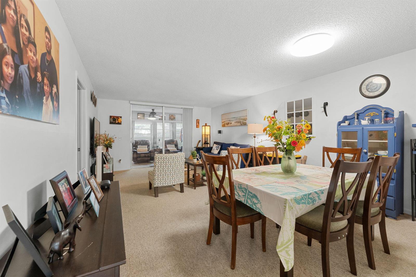 A dining area with a table and chairs sits in front of a living room — 14527 Bonaire Boulevard # 109, Delray Beach FL 33446, DELRAY BEACH, FL