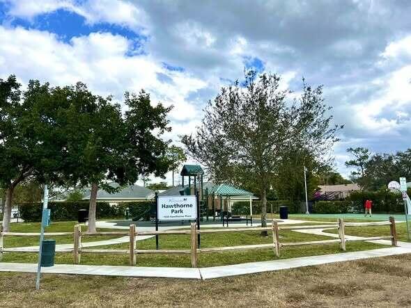 A park features a playground, a basketball court, and a wooden fence under a cloudy sky — 1434 Hawthorne Place, Wellington FL 33414, WELLINGTON, FL