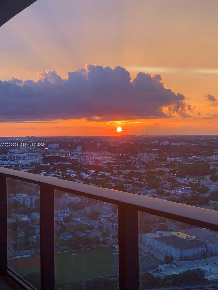 A high-angle view of a city at sunset from a balcony with a glass railing — 1600 NE 1 AVE # 3519, Miami FL 33132, MIAMI, FL