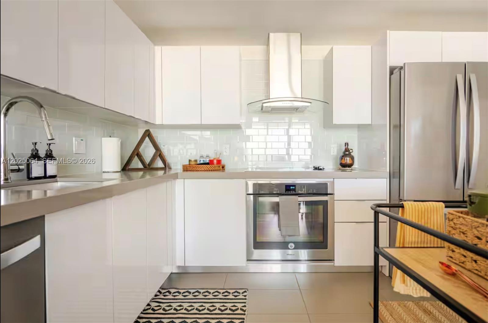 A modern kitchen features white cabinets, stainless steel appliances, and a light-colored subway tile backsplash — 1600 NE 1 AVE # 3519, Miami FL 33132, MIAMI, FL