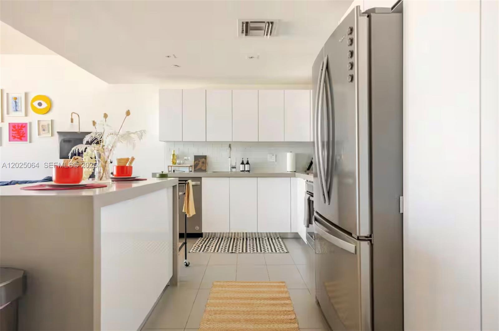 A modern kitchen features white cabinetry, stainless steel appliances, and a gray island countertop — 1600 NE 1 AVE # 3519, Miami FL 33132, MIAMI, FL