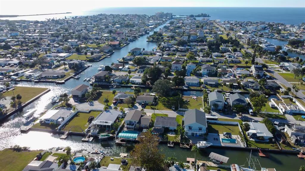 An aerial view of a coastal neighborhood featuring houses situated along interconnected residential canals — 13912 DULEY AVENUE, HUDSON, FL