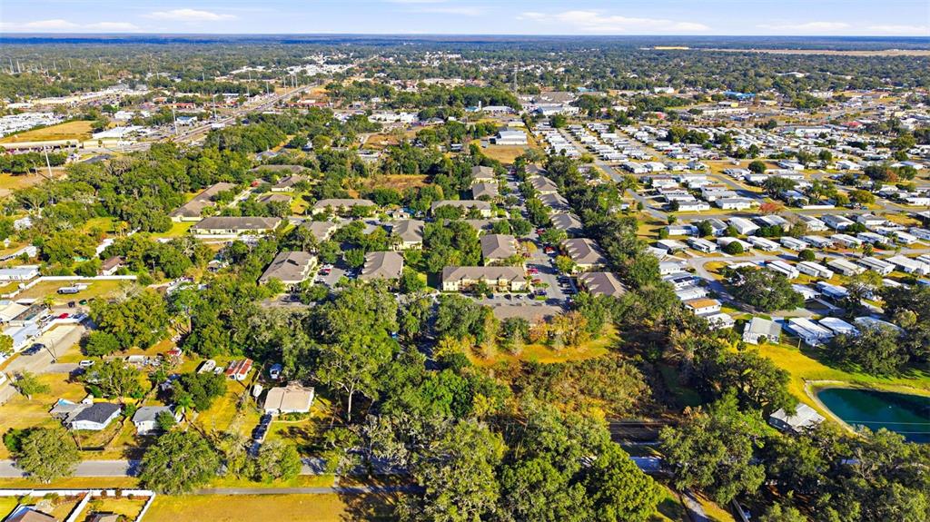 An aerial view shows a residential area with apartment buildings, mobile homes, and green spaces — 37548 DALIHA TERRACE, ZEPHYRHILLS, FL