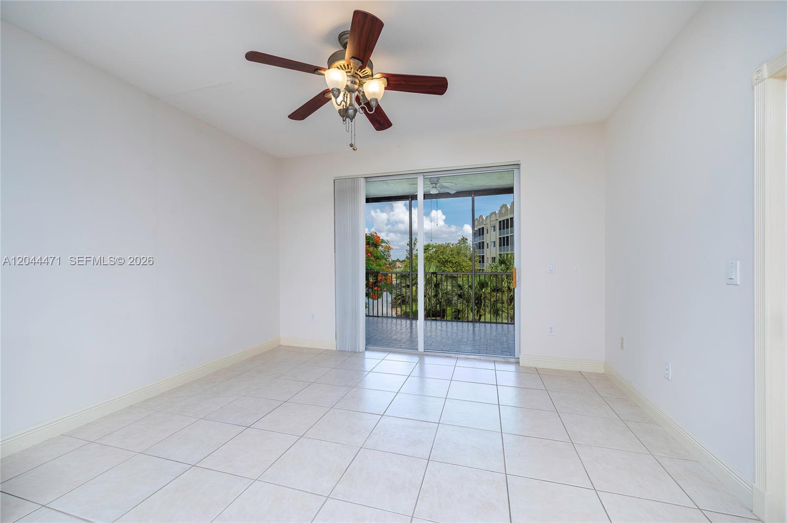 An empty room with white walls, tile flooring, a ceiling fan, and a sliding glass door — 10750 NW 66th St # 312, Doral FL 33178, DORAL, FL