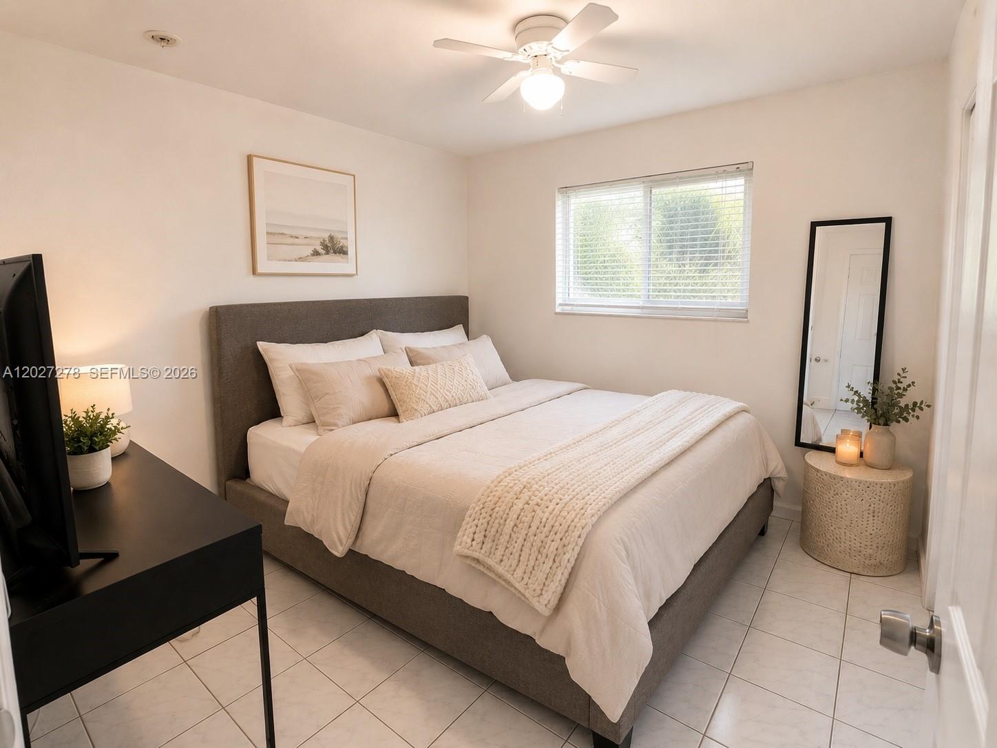A bedroom features a gray upholstered bed, a black desk, and a full-length floor mirror — 901 NE 2nd St, Hallandale Beach FL 33009, HALLANDALE BEACH, FL