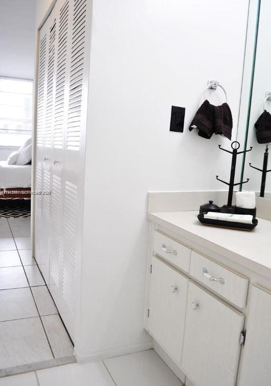 A bathroom vanity with white cabinets, a countertop organizer, and louvered closet doors — 100 Lincoln Rd # 522, Miami Beach FL 33139, MIAMI BEACH, FL