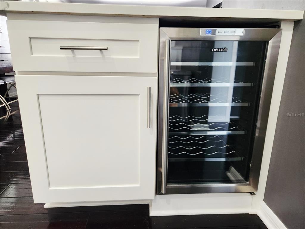 A white kitchen cabinet with a drawer and door sits next to a wine refrigerator — 4651 1ST STREET NE UNIT 306, ST PETERSBURG, FL