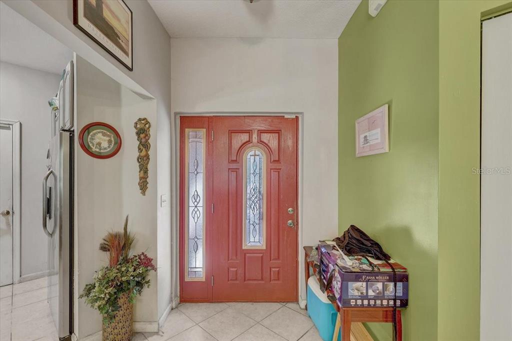 An entryway features a red front door with glass inserts and a green accent wall — 4954 EWELL ROAD, LAKELAND, FL