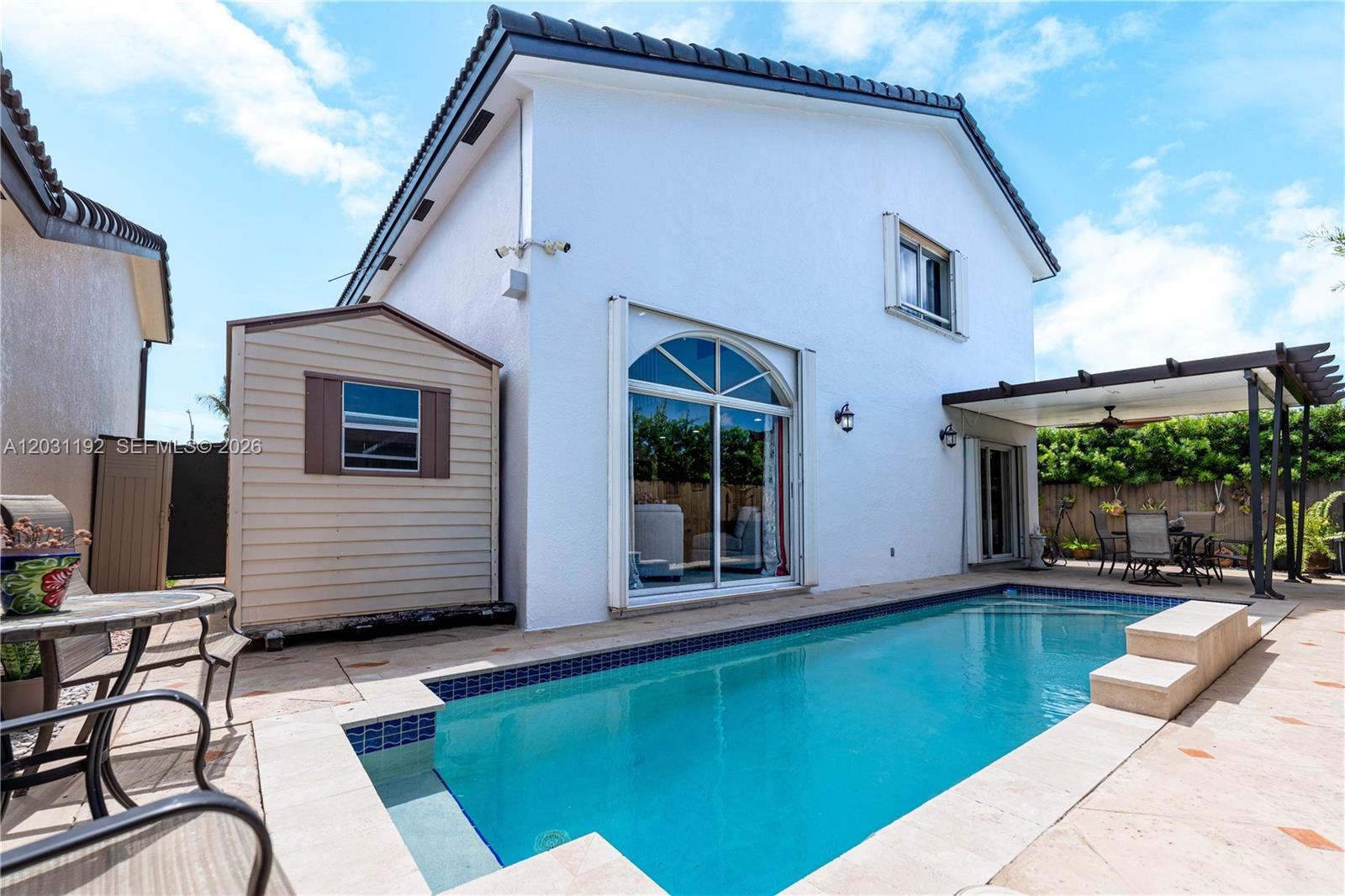 A white two-story house features a swimming pool, a patio, and a storage shed — 1084 SW 142nd Pl, Miami FL 33184, MIAMI, FL