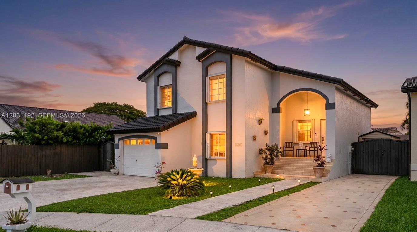 A two-story house with a white stucco exterior, a tiled roof, and a paved driveway — 1084 SW 142nd Pl, Miami FL 33184, MIAMI, FL
