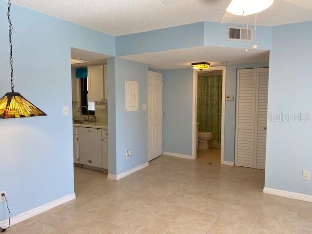 A light blue dining area features a stained-glass pendant light and tile flooring — 19505 QUESADA AVENUE UNIT I202, PORT CHARLOTTE, FL