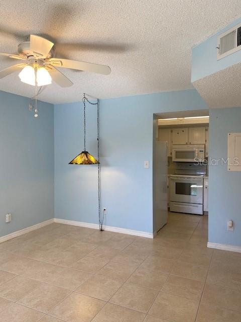 A light blue room features a ceiling fan, a hanging pendant light, and tile flooring — 19505 QUESADA AVENUE UNIT I202, PORT CHARLOTTE, FL
