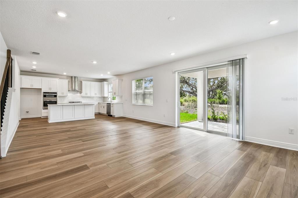 A two-story suburban house with a gray tile roof, beige stucco, and a paved driveway — 7571 HAWKSTONE DRIVE, SARASOTA, FL