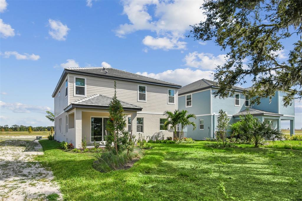 A modern kitchen features white cabinets, stainless steel appliances, a gas cooktop, and quartz countertops — 7571 HAWKSTONE DRIVE, SARASOTA, FL
