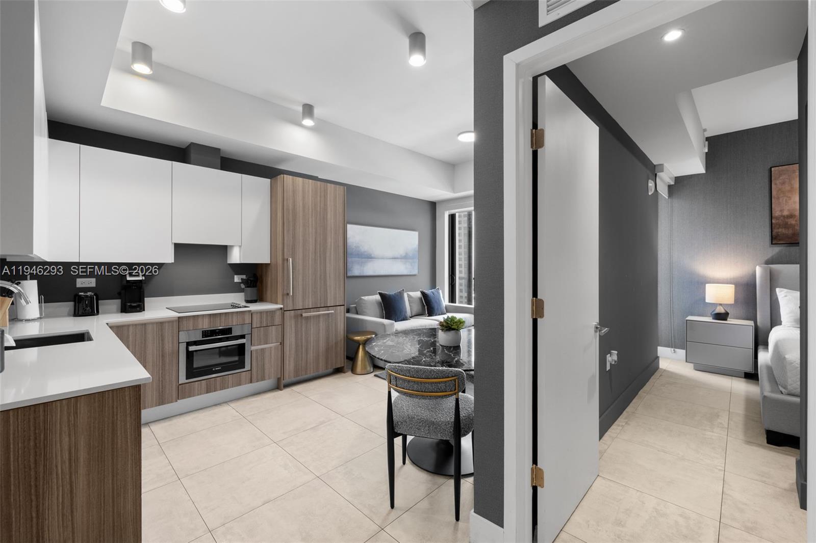 A modern kitchen and dining area open to a living space and adjacent bedroom — 239 SW 9th St # 1604, Miami FL 33130, MIAMI, FL