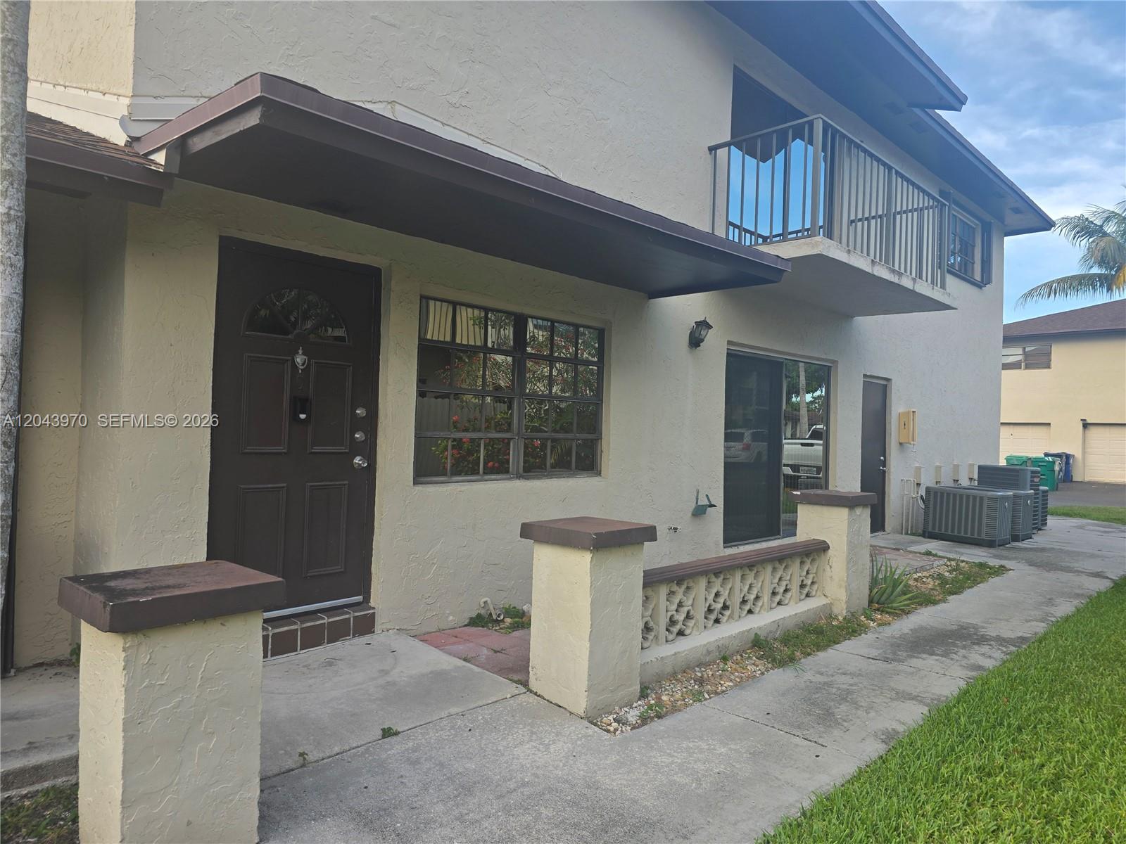 The exterior of a two-story residential building features a brown front door and balcony — 4586 SW 139th Ct # 763, Miami FL 33175, MIAMI, FL