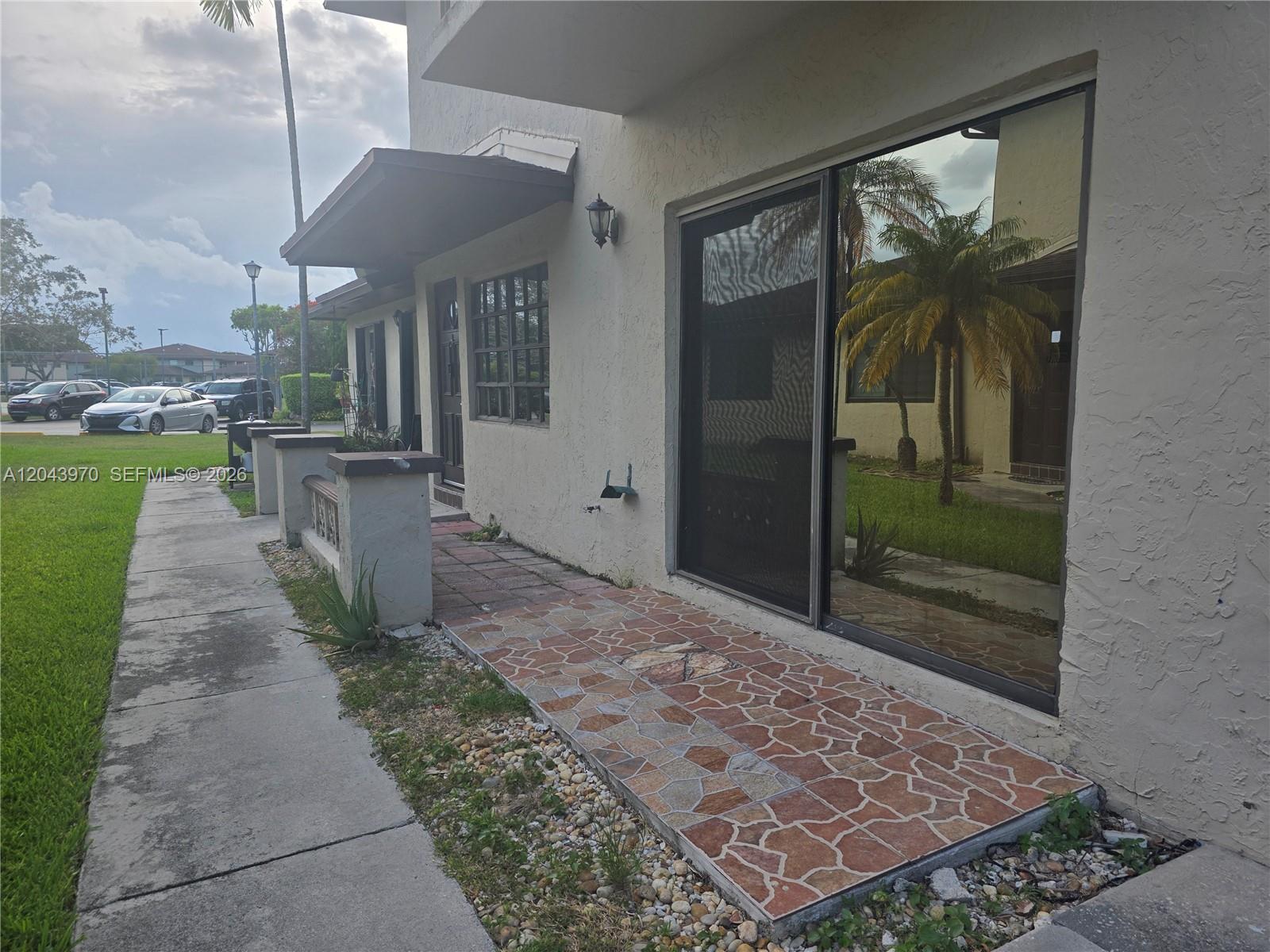 The exterior of a residential building features a tiled patio and a sliding glass door — 4586 SW 139th Ct # 763, Miami FL 33175, MIAMI, FL