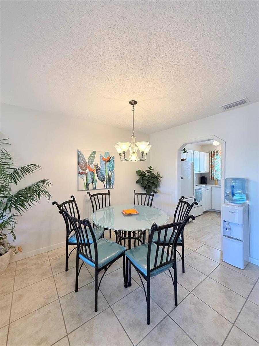 A dining area features a glass-topped table, six black chairs, and a chandelier — 6650 Royal Palm Boulevard # C, Margate FL 33063, MARGATE, FL