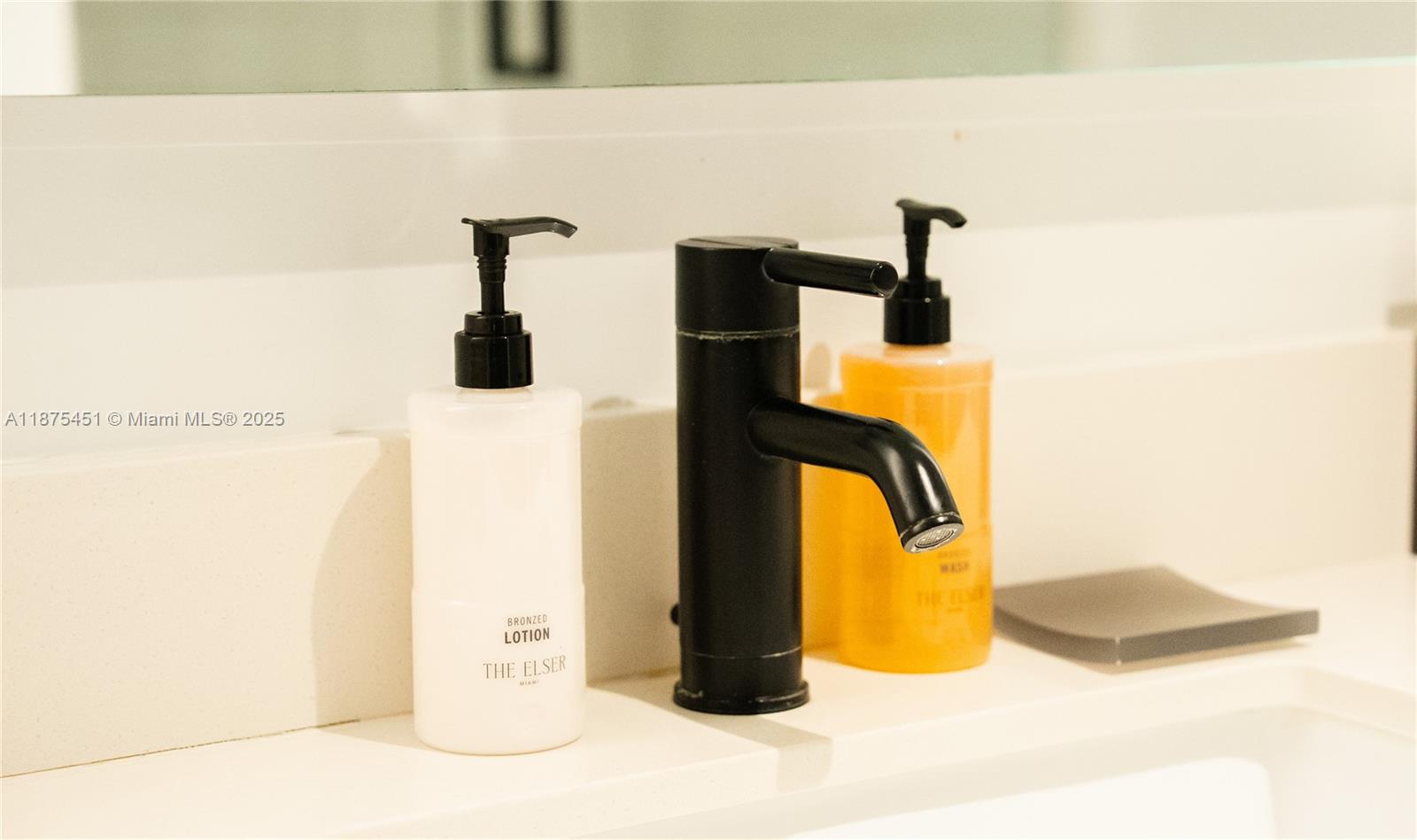 A modern bathroom vanity features a matte black faucet, lotion, and soap dispensers — 398 NE 5th St # 3612, Miami FL 33132, MIAMI, FL