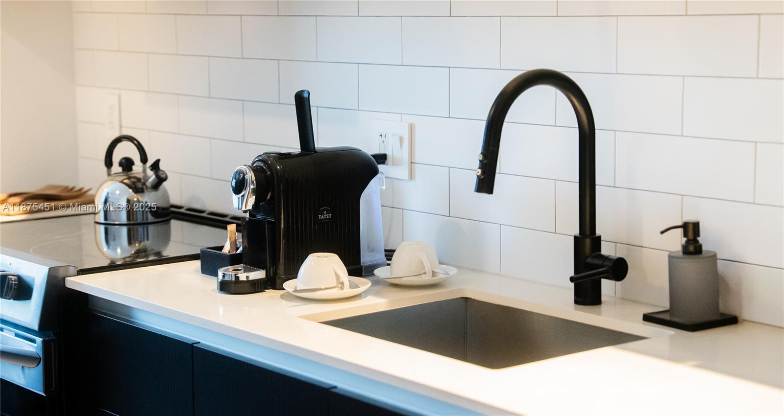 A modern kitchen features a black faucet, a coffee machine, and white subway tile backsplash — 398 NE 5th St # 3612, Miami FL 33132, MIAMI, FL