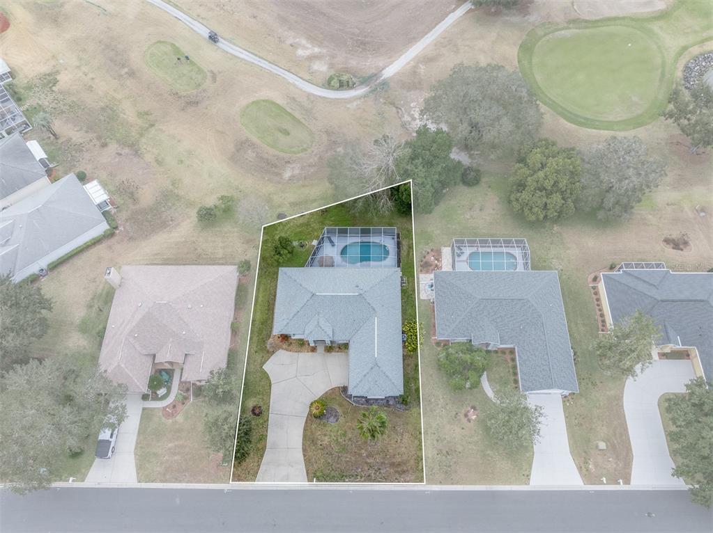 This aerial view shows a single-family home with a screened pool on a golf course — 4740 N CRESTLINE DRIVE, BEVERLY HILLS, FL