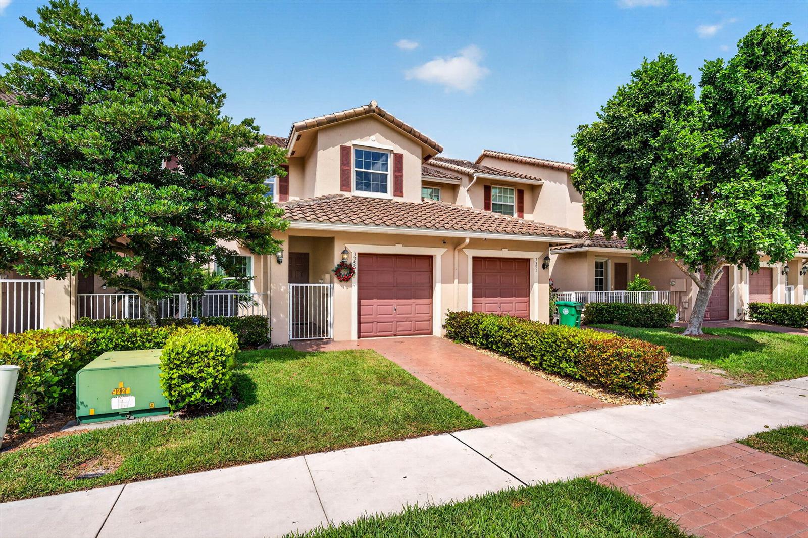 A two-story townhouse with a tile roof, two garage doors, and a landscaped front yard — 3355 Lakeside Drive, Davie FL 33328, DAVIE, FL