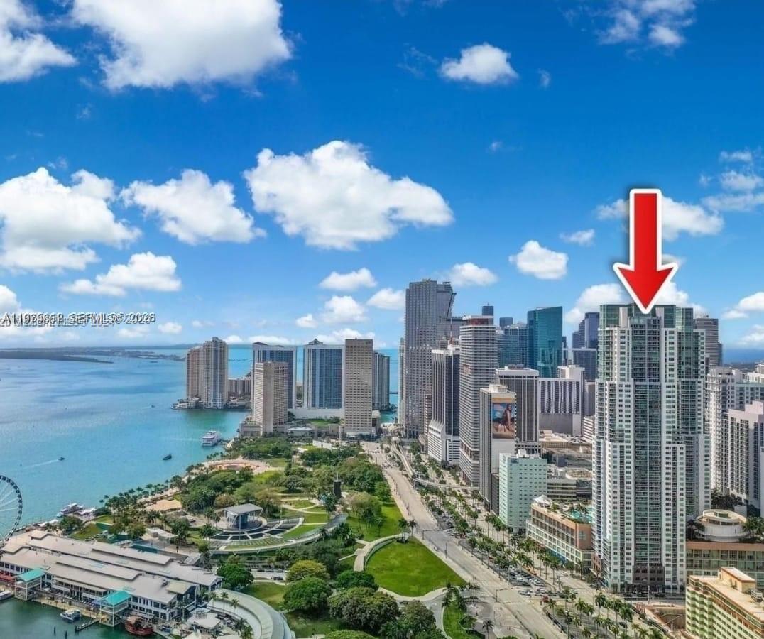 An aerial view of the Miami skyline featuring a tall residential tower marked by an arrow — 244 NE Biscayne Blvd # 440, Miami FL 33132, MIAMI, FL