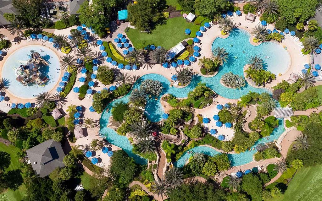 An aerial view of a resort-style swimming pool complex with multiple pools and lounge chairs — 7921 SPECTRUM DRIVE, KISSIMMEE, FL