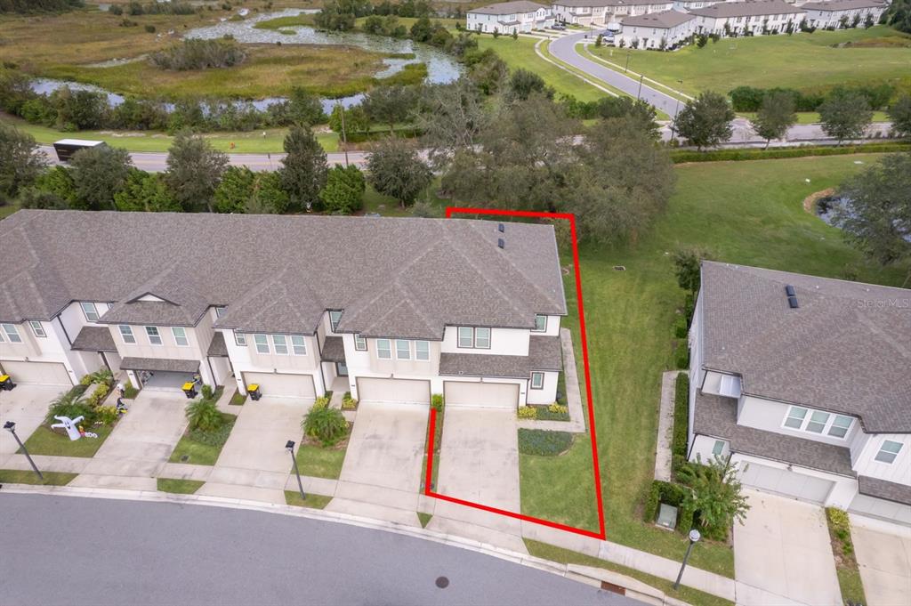 An aerial view shows a townhome with a red outline highlighting its side yard — 664 BENOI DRIVE, DAVENPORT, FL
