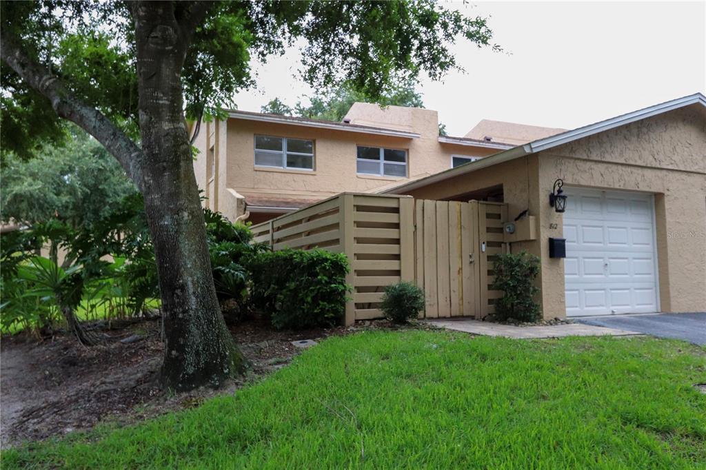 A two-story tan stucco apartment building features a screened-in balcony and landscaped front yard — 812 PARK LAKE CIRCLE UNIT 7, MAITLAND, FL